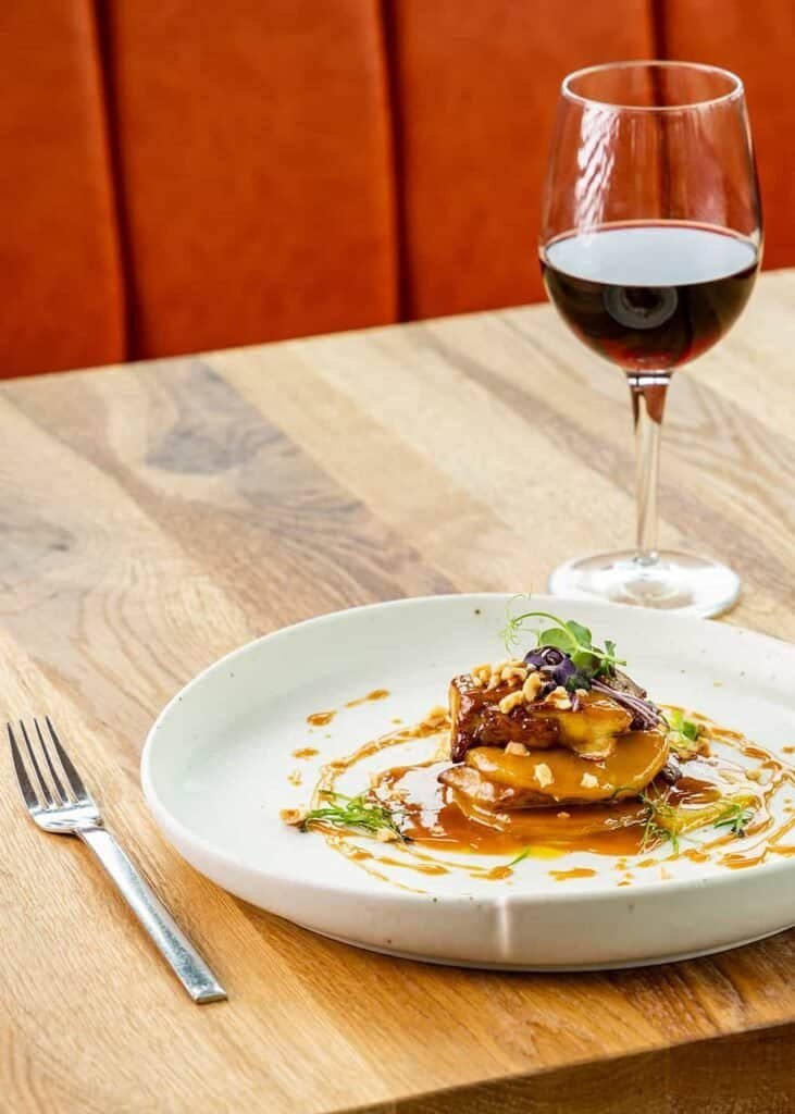 Вкусно ястие с вино, сервирано в елегантна обстановка.